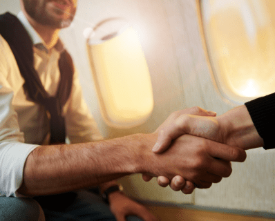 Duas pessoas se cumprimentando no interior de uma aeronave